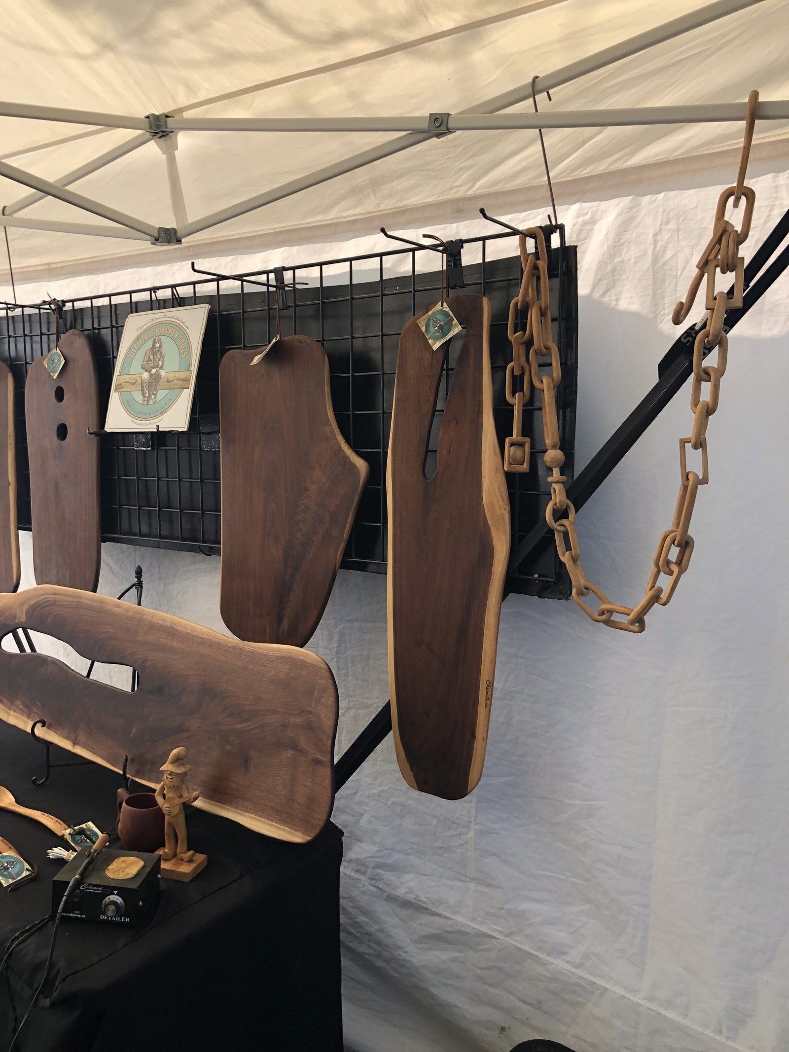 Dark walnut serving boards hanging in the booth beside a long carved wooden chain
